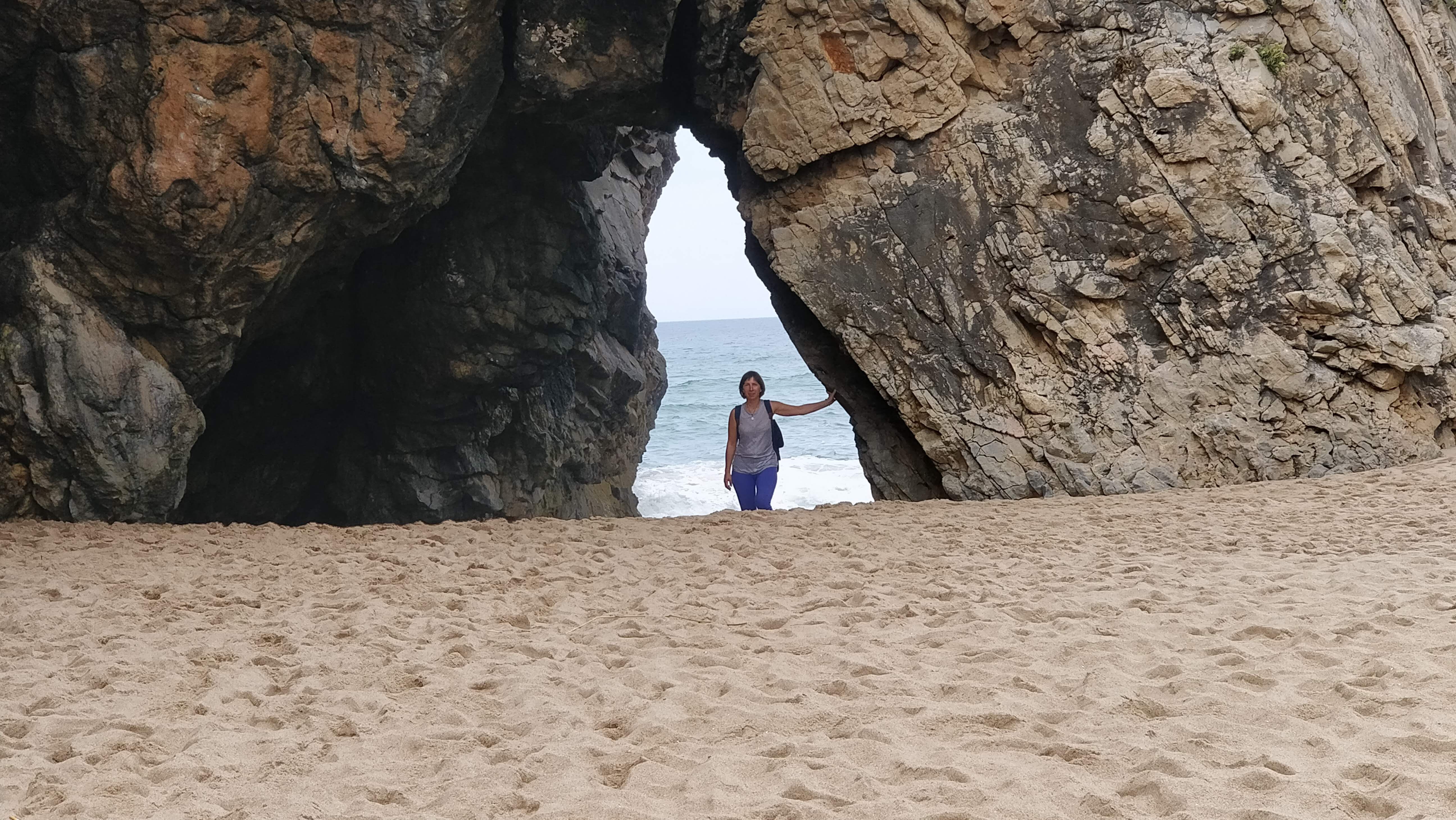 women standing in a cave opening