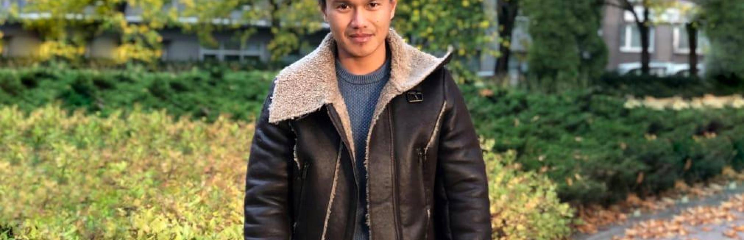 Decorative image of RJ standing in a park