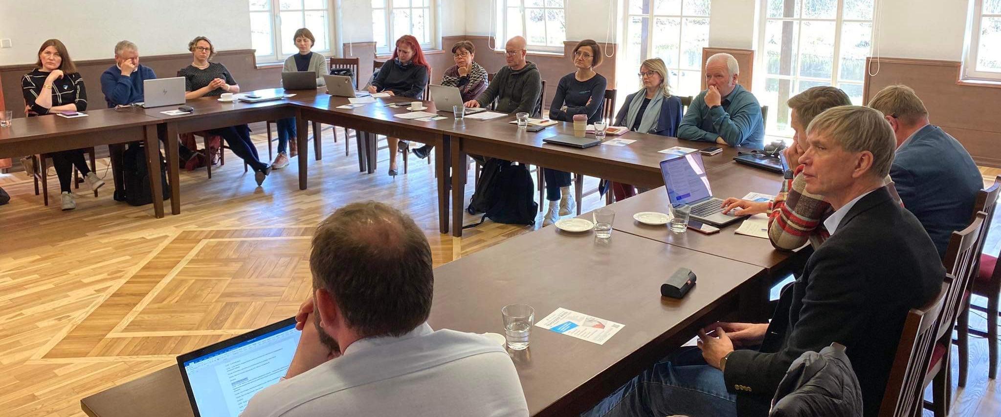 20 people sitting around U -shaped desk