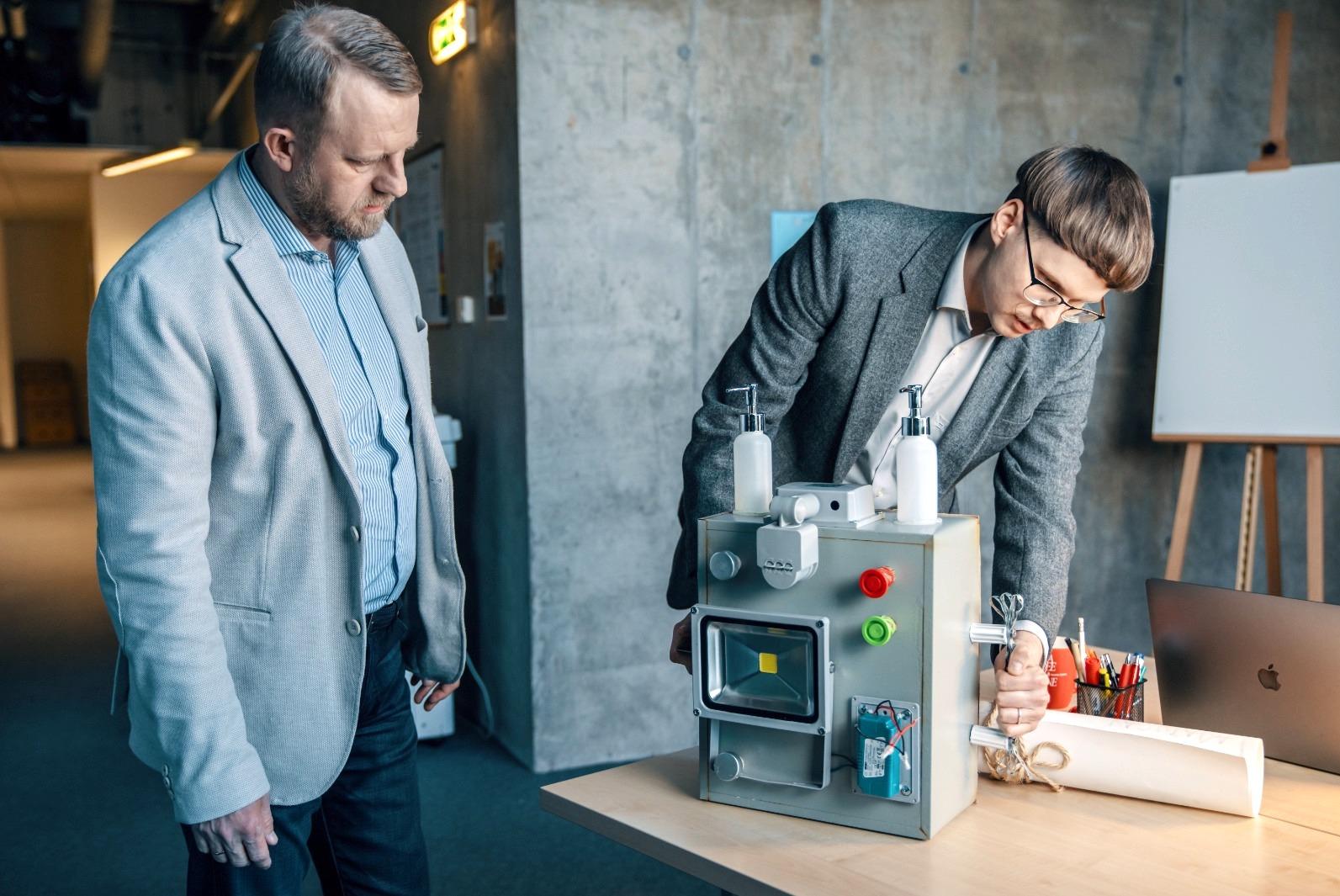 Pilt on illustratiivne. Two men looking at a strange machine