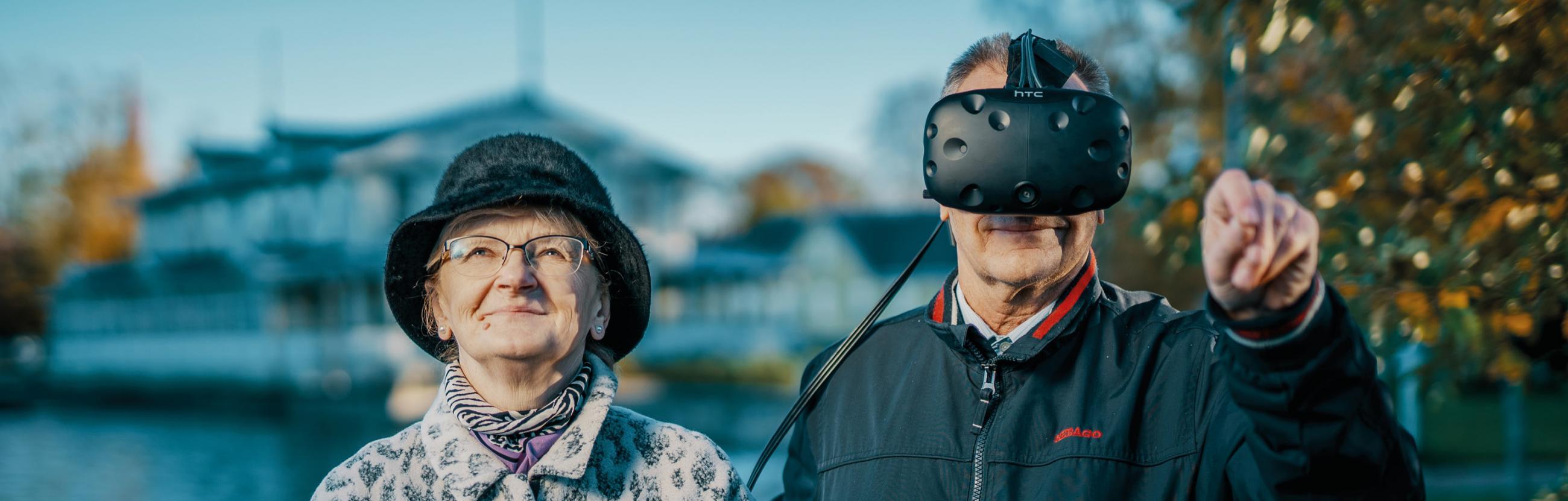 Vanem naine ja mees - mees kannab virtuaalreaalsusprille - seisavad Haaspsalu promenaadil kuursaali ees