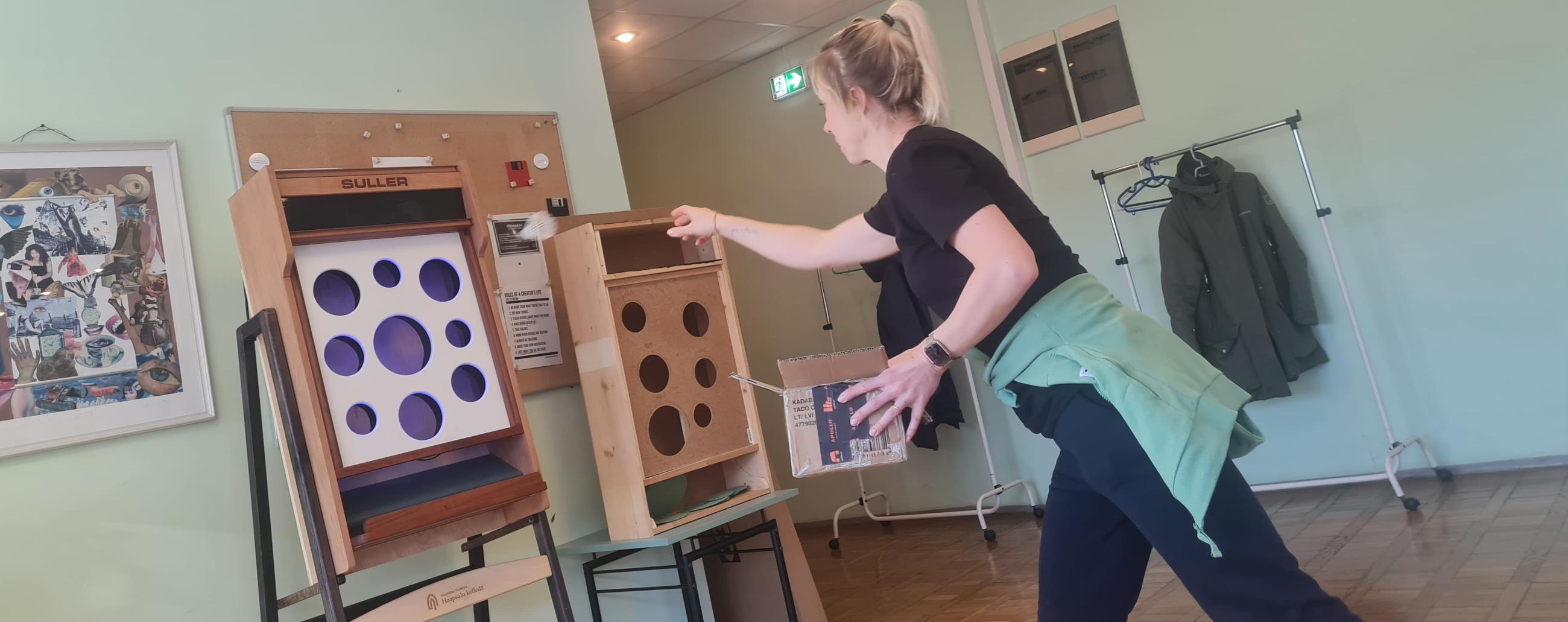 Tütarlaps mängib sulgpalliga uut loodud mängu kolledži koridoris