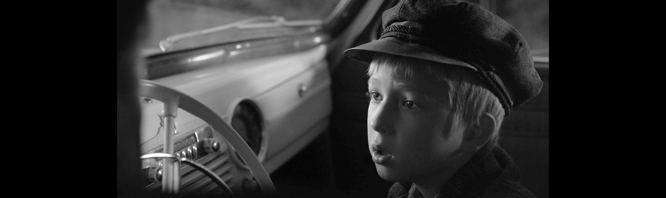 A frame from the film A Car Called Victory Young boy sitting in a car
