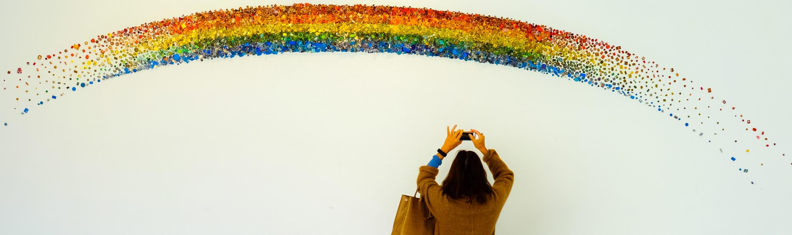 girl taking a photo of a rainbow