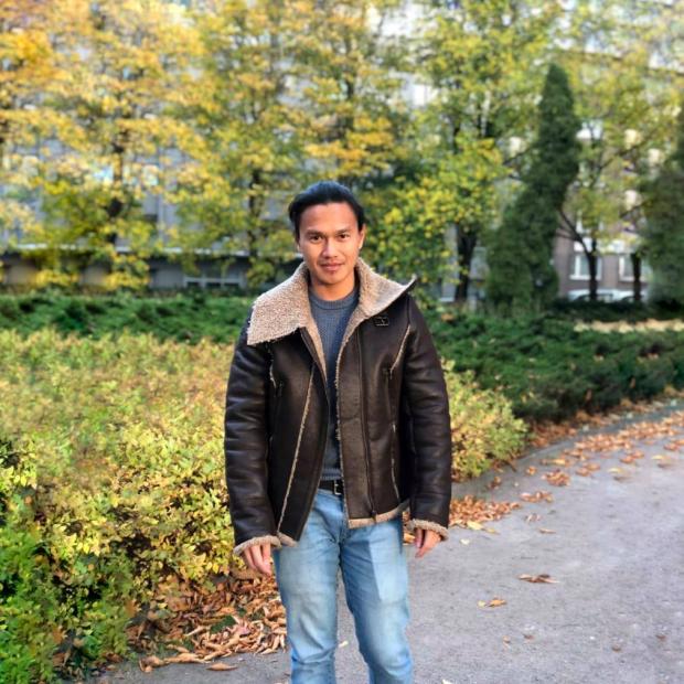 Decorative image of RJ standing in a park