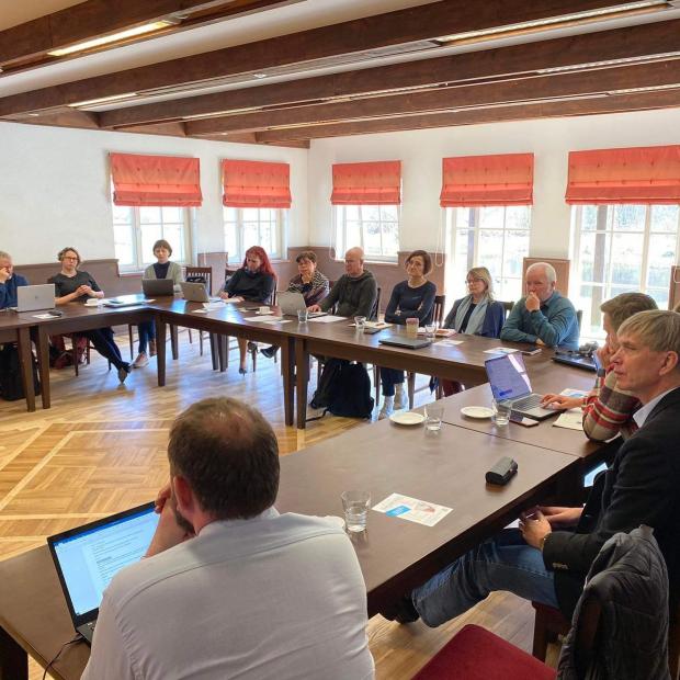 20 people sitting around U -shaped desk