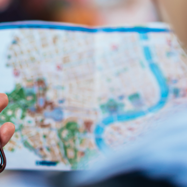 Telefon käes, kaardiga linnas orienteerumine