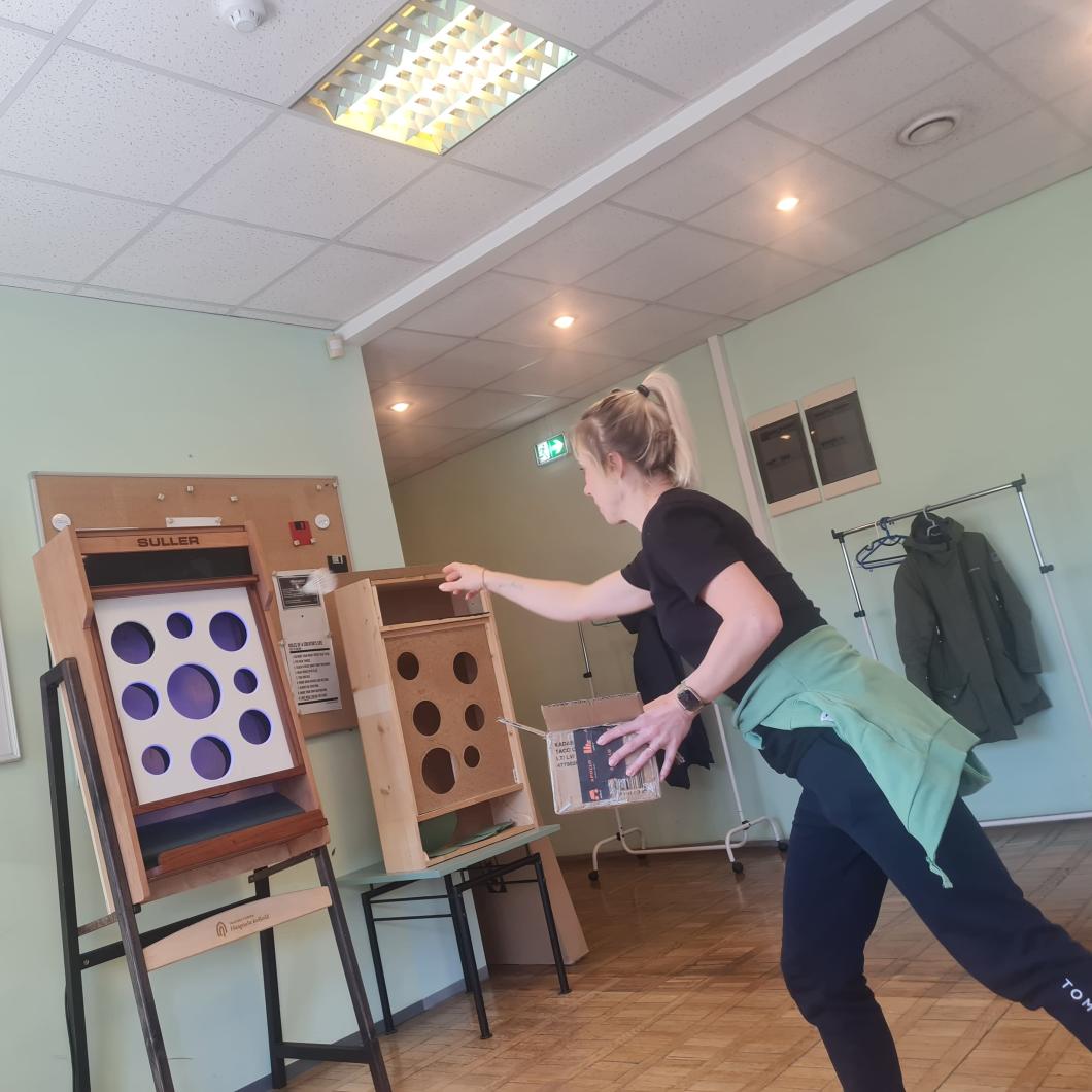 Tütarlaps mängib sulgpalliga uut loodud mängu kolledži koridoris